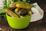 pickled cucumbers in green wooden bowl