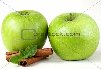 Granny Smith green apples with cinnamon and mint on a white background