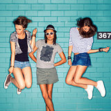 young people having fun in front of light blue brick wall