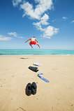 businessman jumping on the beach