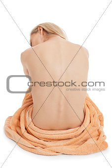 young blonde woman sitting on towel naked back isolated 