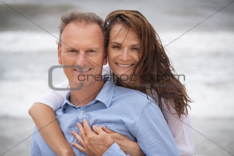 happy adult couple in summertime on beach 