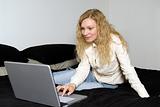 Woman with laptop on het bed.