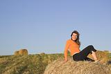 Beautiful woman in a field with hay bales