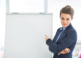 Business woman pointing on flipchart
