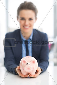 Closeup on happy business woman holding piggy bank