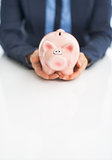 Closeup on business woman holding piggy bank