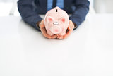 Closeup on business woman holding piggy bank