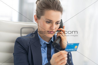 Business woman with credit card talking phone