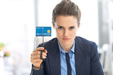 Serious business woman cutting credit card with scissors