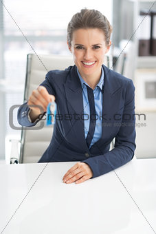 Happy business woman giving keys