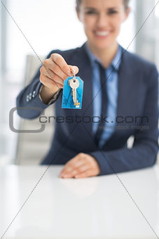 Closeup on happy business woman giving keys