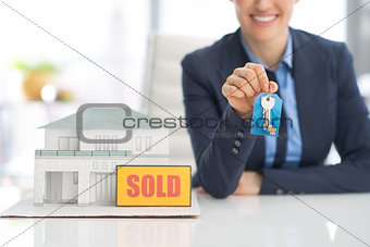 Closeup on happy realtor woman showing keys