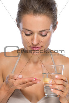 Young woman eating pill