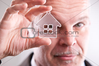Man looking through a little house in front of you
