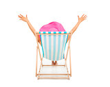 relaxed woman sitting on beach chairs and raise hands
