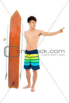 young man standing and point forward with surfboard