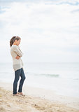 Thoughtful young woman standing on cold beach