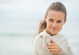 Happy young woman on cold beach looking on copy space