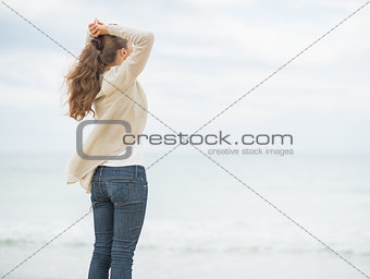 Young woman on cold beach looking into distance