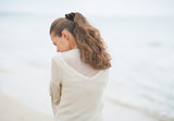 Closeup on young woman walking on cold beach. rear view