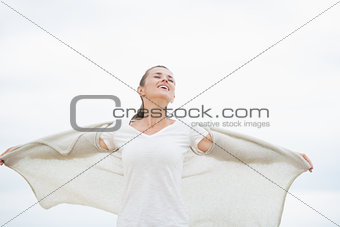 Young woman on cold beach rejoicing