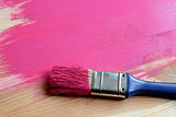 Paint-covered paintbrush on painted wood