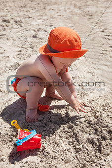 Happy little baby playing on the beach