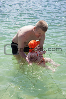 Father and little baby girl in sea 