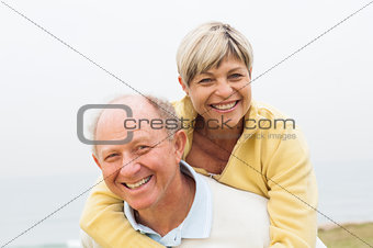 Mature man giving woman piggyback