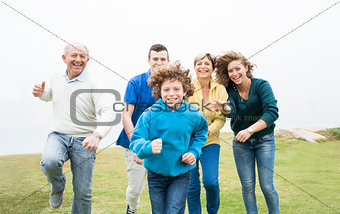 Happy family running on a green meadow
