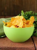 natural potato chips with paprika in a bowl on a wooden table