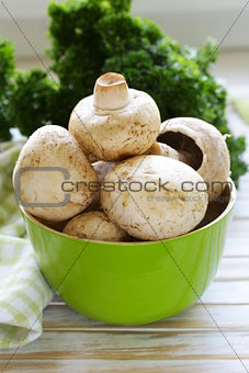 Fresh organic champignon mushrooms on a wooden table