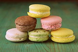 French multicolored macaroons cookies on a vintage wooden background