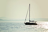 Sailboat silhouette on open water