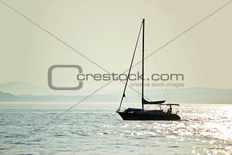 Sailboat silhouette on open water