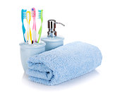 Four colorful toothbrushes, liquid soap and towel