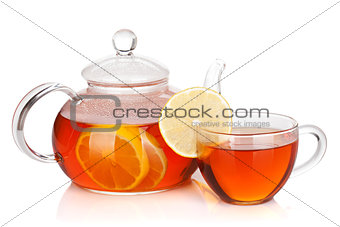 Glass cup and teapot of black tea with lemon