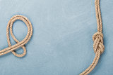 Ship rope knot on wooden texture background