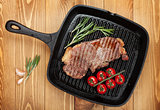 Sirloin steak with rosemary and cherry tomatoes on frying pan