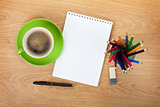 Blank notepad with office supplies and green coffee cup