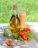 Olive oil bottle, pepper shaker, tomatoes and herbs