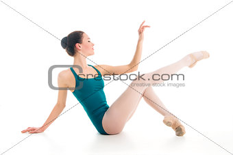 elegant young ballet dancer posing on floor