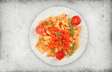 Fusilli pasta with tomato sauce and arugula