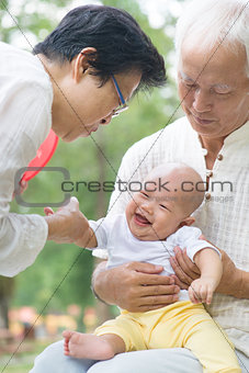 Asian grandparents playing with grandchild