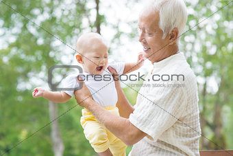 Asian grandfather playing with grandson