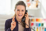 Portrait of happy fashion designer talking phone with crossed fi