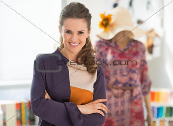 Happy fashion designer and dressed mannequin in background