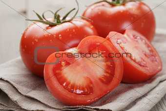 fresh ripe tomatoes with halfs on wood table