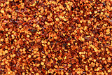 Dried chilli flakes and seeds abstract background texture